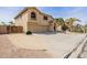 Two-story home with a three-car garage, desert landscaping, and a gated side yard at 565 E Rosebud Dr, San Tan Valley, AZ 85143