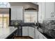 Kitchen with white cabinets, black countertops, and stainless steel appliances at 565 E Rosebud Dr, San Tan Valley, AZ 85143