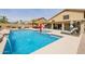 Backyard pool with fountains, covered patio, lounge chairs and desert landscaping at 565 E Rosebud Dr, San Tan Valley, AZ 85143