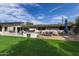 Spacious backyard with multiple patio areas, a built-in barbecue, and a lush green lawn perfect for outdoor gatherings at 5960 E Orange Blossom Ln, Phoenix, AZ 85018