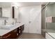 Contemporary bathroom featuring double sinks, a glass shower, and modern finishes at 5960 E Orange Blossom Ln, Phoenix, AZ 85018