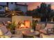 Relaxing backyard with modern outdoor fireplace feature, seating area, and lush greenery at 5960 E Orange Blossom Ln, Phoenix, AZ 85018
