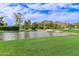 Picturesque golf course with a serene pond, lush green grass, sand traps, and stunning mountain views in the background at 5960 E Orange Blossom Ln, Phoenix, AZ 85018