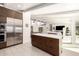 Open concept living with kitchen island with seating, modern lighting, and stainless steel appliances at 5960 E Orange Blossom Ln, Phoenix, AZ 85018