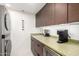 Convenient laundry area features a stacked washer/dryer and a sink with light green countertop at 5960 E Orange Blossom Ln, Phoenix, AZ 85018