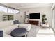 Bright living room featuring a sectional couch, hardwood floors, and a large television at 5960 E Orange Blossom Ln, Phoenix, AZ 85018