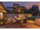 Inviting backyard patio with outdoor dining under an umbrella of lights at dusk at 5960 E Orange Blossom Ln, Phoenix, AZ 85018