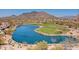 An aerial view showcases the serene lake and lush golf course winding through the community, with mountains in the background at 6522 E Night Glow Cir, Scottsdale, AZ 85266