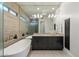 Modern bathroom featuring a soaking tub, glass shower, and gray vanity with double sinks at 6522 E Night Glow Cir, Scottsdale, AZ 85266