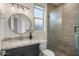 Bathroom with a round mirror above a dark vanity with granite countertops, and a glass enclosed shower at 6522 E Night Glow Cir, Scottsdale, AZ 85266