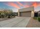 Inviting home with a two-car garage, desert landscaping, and a concrete driveway at sunset at 6522 E Night Glow Cir, Scottsdale, AZ 85266