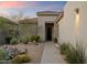 Inviting front entrance with desert landscaping, stone pathway, and a black front door at 6522 E Night Glow Cir, Scottsdale, AZ 85266