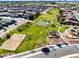 An aerial view of a community park featuring green spaces, a playground, a basketball court, and walking trails at 690 W Mangrove Rd, Queen Creek, AZ 85140