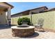 Cozy backyard with a stone fire pit, seating area, and lush landscaping at 690 W Mangrove Rd, Queen Creek, AZ 85140