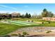 Community park featuring bocce ball courts, benches, picnic tables, and lush landscaping, perfect for outdoor recreation at 690 W Mangrove Rd, Queen Creek, AZ 85140