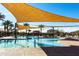 Community pool with lounge chairs, splash pad, and shade sails for a fun and relaxing day at 690 W Mangrove Rd, Queen Creek, AZ 85140
