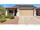 Charming single-story home featuring a well-manicured front yard and brick-paved driveway leading to a two-car garage at 690 W Mangrove Rd, Queen Creek, AZ 85140