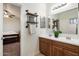 Bathroom featuring double sinks, mirrors, wood cabinets, and an open door into the bedroom at 7238 W El Cortez Pl, Peoria, AZ 85383