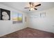 Neutral bedroom with a ceiling fan and multiple windows, and textured accent wall and area rug at 7238 W El Cortez Pl, Peoria, AZ 85383
