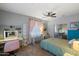 Bedroom featuring pink curtains, an area rug, white shelves, and modern furniture and a large bed at 7238 W El Cortez Pl, Peoria, AZ 85383