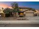 Charming home exterior at dusk featuring a well-maintained yard and attached two-car garage at 7238 W El Cortez Pl, Peoria, AZ 85383