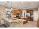 Well-lit kitchen with wood cabinets, granite counters, stainless appliances, tile backsplash, and eat-in island at 7238 W El Cortez Pl, Peoria, AZ 85383