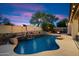 Inviting backyard pool with rock waterfall feature and poolside torches for cozy outdoor ambiance at 7238 W El Cortez Pl, Peoria, AZ 85383