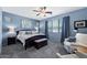 Stylish bedroom featuring blue walls, carpeted floors, a ceiling fan, and comfortable seating near a bright window at 7554 E Globemallow Ln, Gold Canyon, AZ 85118