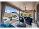 Outdoor living space with comfortable seating, a dining area, and views of the pool and beautifully landscaped yard at 7554 E Globemallow Ln, Gold Canyon, AZ 85118