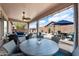 Covered patio with outdoor seating, perfect for relaxing and overlooking the pool and lush backyard at 7554 E Globemallow Ln, Gold Canyon, AZ 85118