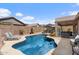 Backyard swimming pool with lounge seating, a covered patio and lush landscaping at 7554 E Globemallow Ln, Gold Canyon, AZ 85118