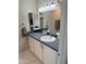 This bathroom features a vanity with a granite countertop, a mirror, and white cabinets at 8260 E Arabian Trl # 275, Scottsdale, AZ 85258