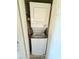Stacked white washer and dryer unit tucked away in a closet at 8260 E Arabian Trl # 275, Scottsdale, AZ 85258