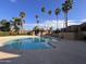 Community pool featuring multiple palm trees, lounge chairs, and an easy access staircase entry at 8260 E Arabian Trl # 275, Scottsdale, AZ 85258