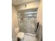 Clean tiled shower with glass doors, pebble floor, and a built-in shelf in a well-lit bathroom at 8260 E Arabian Trl # 275, Scottsdale, AZ 85258