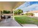 Covered patio overlooking large, well-maintained backyard with lush lawn and mature trees providing shade at 844 W Sherri Dr, Gilbert, AZ 85233
