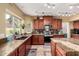 Beautiful kitchen featuring granite countertops, dark wood cabinets, stainless steel appliances, and natural light at 844 W Sherri Dr, Gilbert, AZ 85233