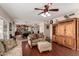 Open-concept living room with a glimpse of the kitchen, featuring a large sofa, ottoman, and hardwood floors at 844 W Sherri Dr, Gilbert, AZ 85233