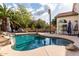 Beautiful pool with rock features, set within a backyard, complete with palm trees and patio furniture at 844 W Sherri Dr, Gilbert, AZ 85233