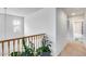 Bright hallway with wood railing staircase and plants creating a serene atmosphere at 9364 W Cordes Rd, Tolleson, AZ 85353