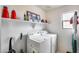 Functional laundry room with modern washer, dryer and overhead storage shelf at 9364 W Cordes Rd, Tolleson, AZ 85353