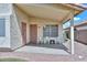 Covered patio with white chairs, outdoor ceiling fan, and security doors leading to side yard at 9837 W Tonopah Dr, Peoria, AZ 85382