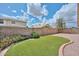 Backyard with artificial grass, privacy fence, and stone landscaping for low maintenance at 9837 W Tonopah Dr, Peoria, AZ 85382