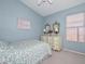 Bedroom featuring charming vanity and blue walls, window and patterned bedding at 9837 W Tonopah Dr, Peoria, AZ 85382