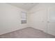 Bedroom with neutral colored walls and carpet, featuring a window and a closet at 9837 W Tonopah Dr, Peoria, AZ 85382