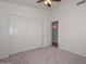 Bright bedroom features neutral carpet, a ceiling fan, and a spacious closet with sliding doors at 9837 W Tonopah Dr, Peoria, AZ 85382