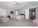 Cozy bedroom features floral bedding, an area for seating, and lots of natural light at 9837 W Tonopah Dr, Peoria, AZ 85382