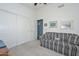 Bright bedroom with a plaid couch, closet, and artwork for a relaxing space at 9837 W Tonopah Dr, Peoria, AZ 85382