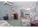 Comfortable bedroom featuring floral wallpaper, chair with ottoman, and a large mirror at 9837 W Tonopah Dr, Peoria, AZ 85382