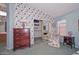 Bedroom showcases floral wallpaper, chair, large closet, and a charming vanity at 9837 W Tonopah Dr, Peoria, AZ 85382